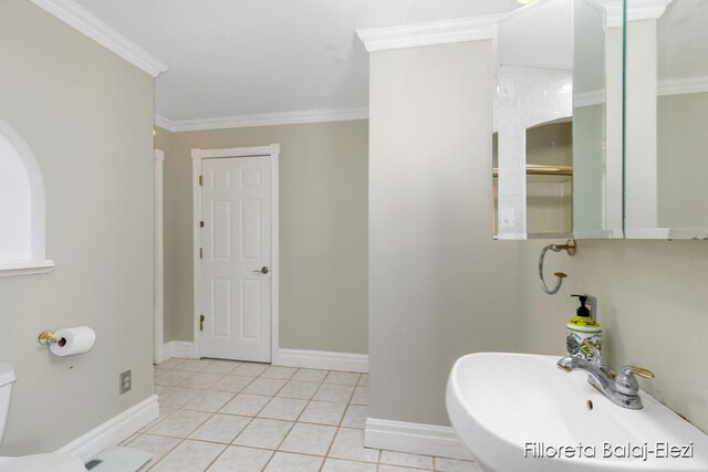 bathroom featuring toilet, ornamental molding, sink, and tile patterned flooring