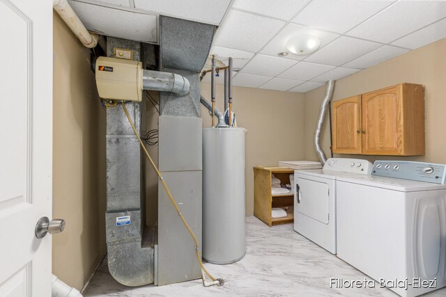 washroom with washing machine and clothes dryer, heating unit, and gas water heater