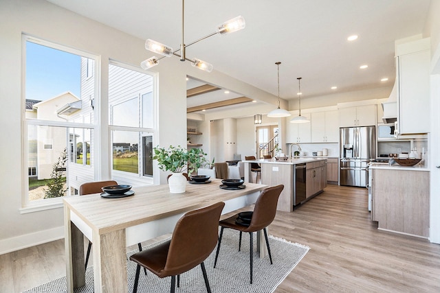 dining space featuring light wood-type flooring and sink