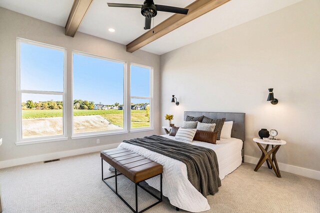 carpeted bedroom featuring beamed ceiling and ceiling fan