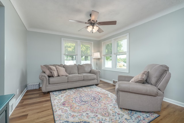 living room featuring ceiling fan, wood-type flooring, and crown molding