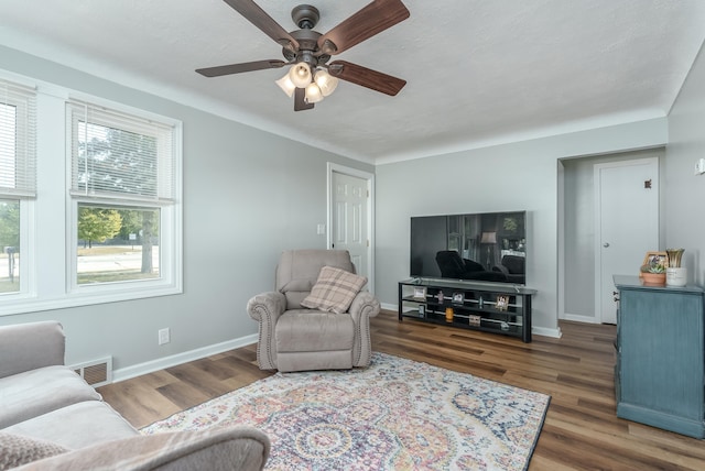 living room featuring dark hardwood / wood-style flooring and ceiling fan