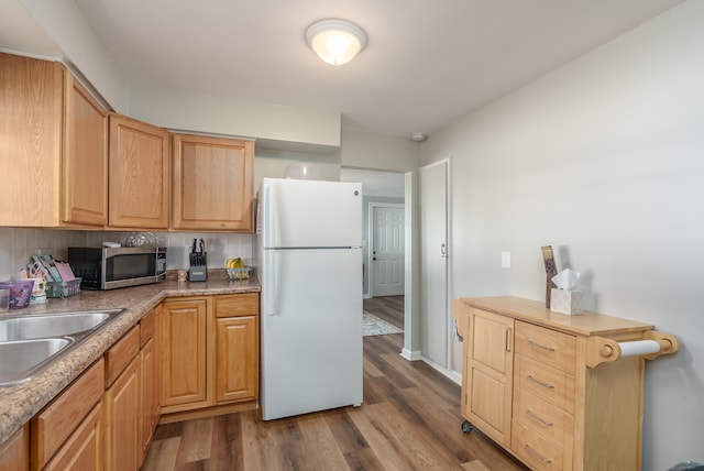 kitchen featuring sink, tasteful backsplash, light brown cabinetry, white refrigerator, and light wood-type flooring