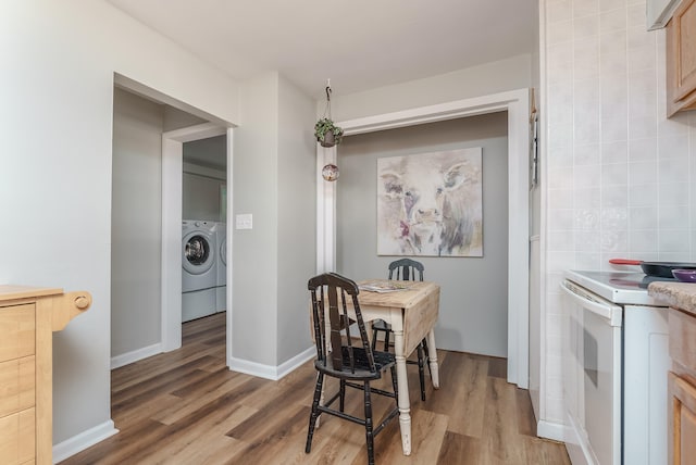 dining space featuring washer / clothes dryer and wood-type flooring