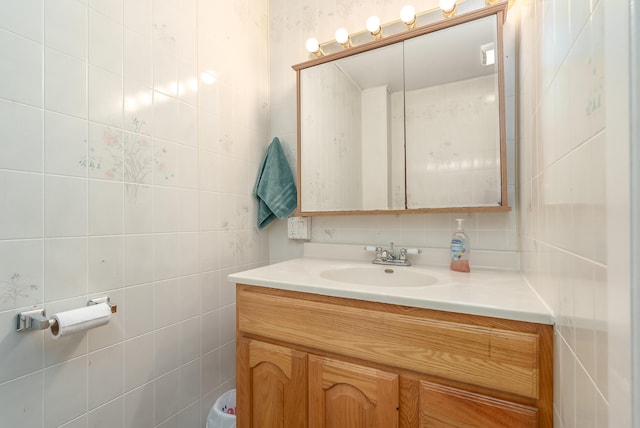 bathroom featuring vanity, tile walls, and tasteful backsplash