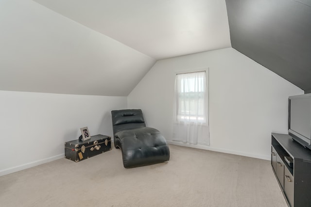 living area featuring lofted ceiling and light colored carpet