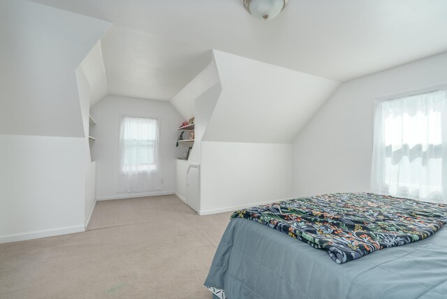 bedroom featuring light colored carpet and lofted ceiling