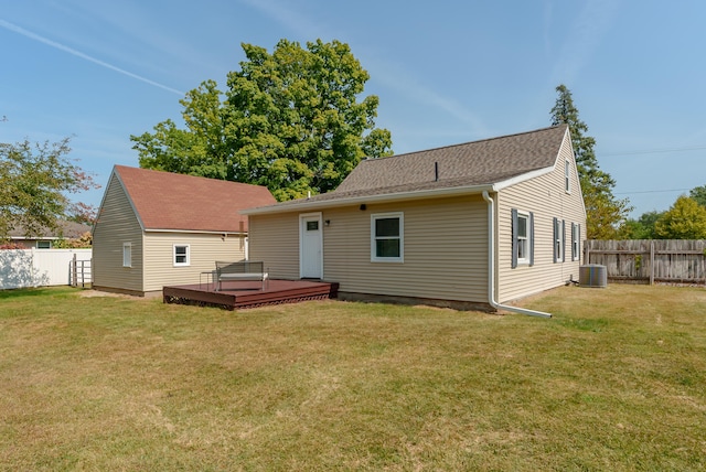 back of property featuring cooling unit, a yard, and a deck