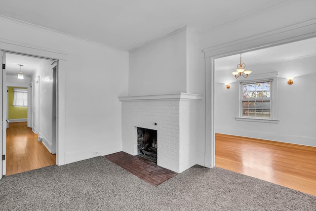 unfurnished living room with a fireplace, hardwood / wood-style flooring, a notable chandelier, and ornamental molding