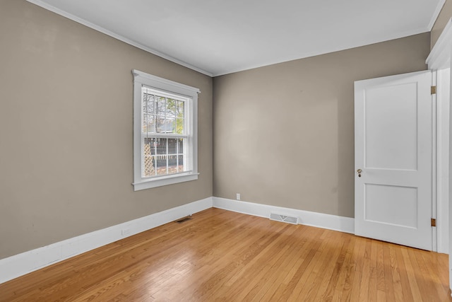 empty room with light hardwood / wood-style flooring and crown molding