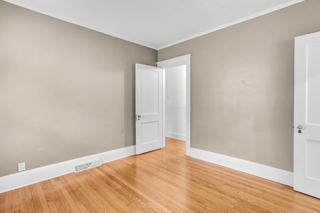 unfurnished room with ornamental molding and light hardwood / wood-style floors