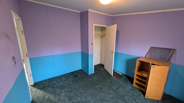 unfurnished bedroom with a closet, dark carpet, and ornamental molding