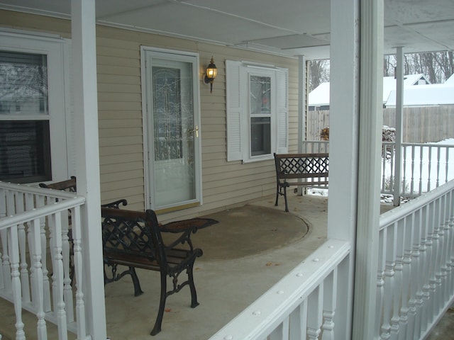 snow covered patio featuring covered porch