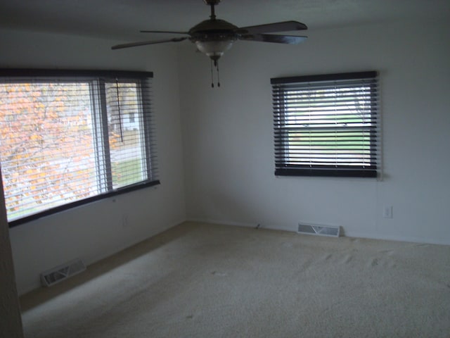 unfurnished room featuring carpet flooring, ceiling fan, and plenty of natural light