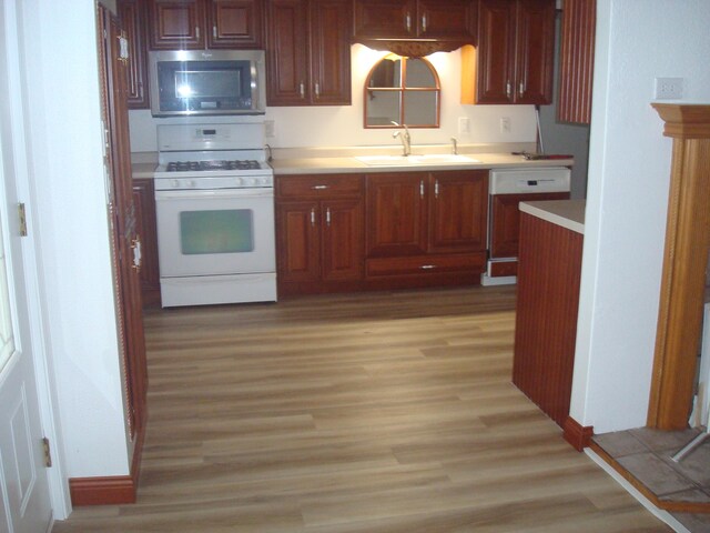 kitchen with sink, light hardwood / wood-style floors, and white appliances