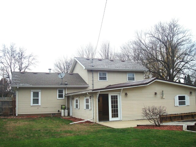 rear view of house with a patio and a lawn