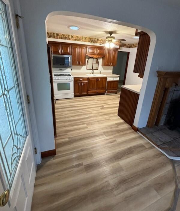 kitchen featuring white range, light hardwood / wood-style floors, and ceiling fan