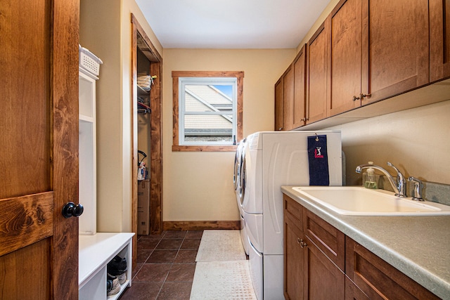 laundry room featuring cabinets, dark tile patterned floors, and sink