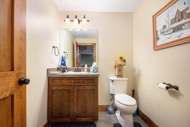 bathroom featuring tile patterned flooring, vanity, and toilet