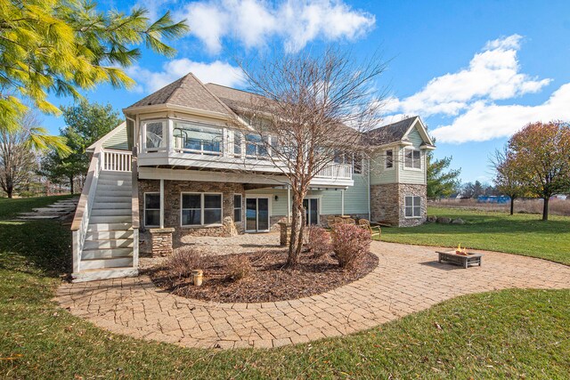 rear view of property featuring a yard and an outdoor fire pit