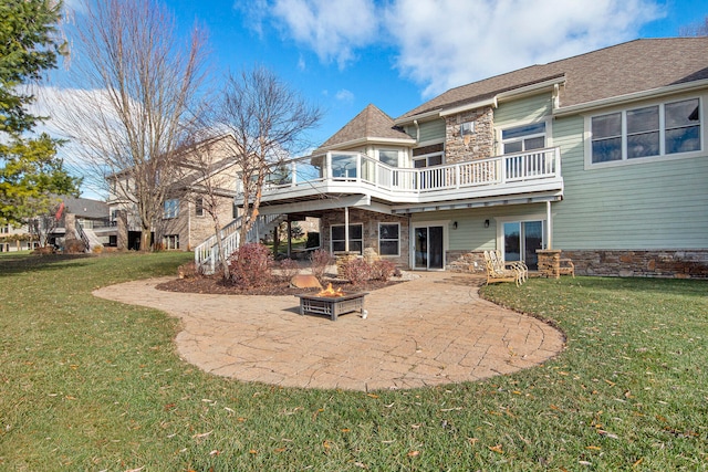 rear view of house with a yard, a balcony, and a patio