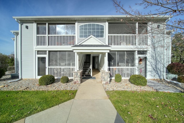 view of front of home featuring a front lawn and a sunroom