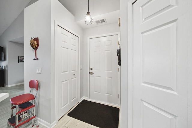 entryway featuring light wood-type flooring and vaulted ceiling