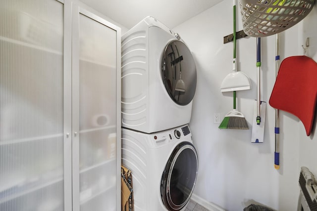 clothes washing area with stacked washing maching and dryer