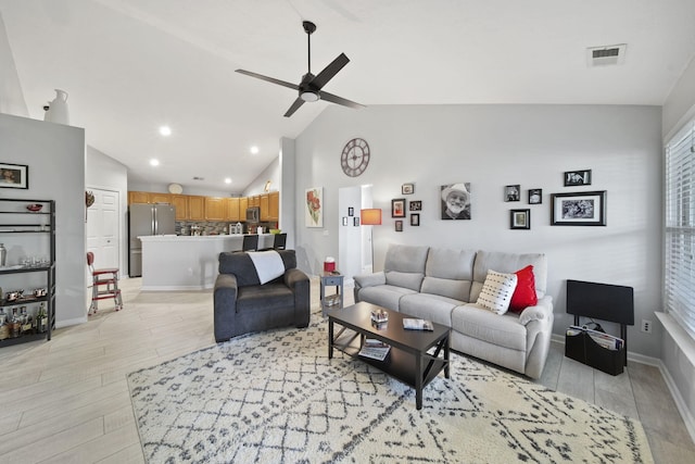 living room with ceiling fan, lofted ceiling, and light wood-type flooring