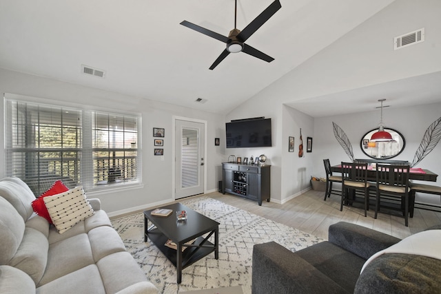 living room with ceiling fan, high vaulted ceiling, and light wood-type flooring