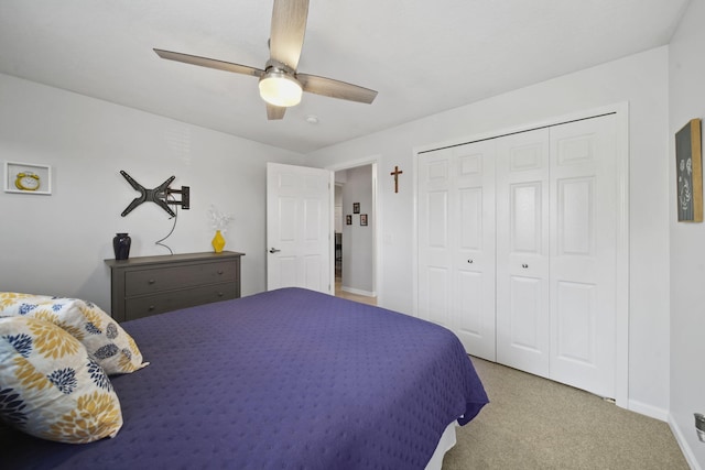 bedroom with ceiling fan, light colored carpet, and a closet