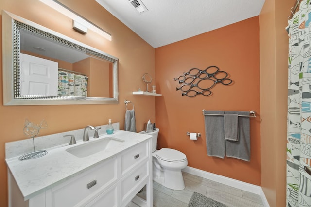 bathroom with tile patterned floors, vanity, toilet, and a textured ceiling