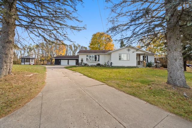 ranch-style house with a front yard, an outbuilding, and a garage