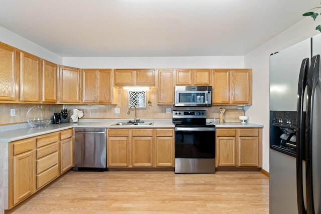 kitchen featuring light hardwood / wood-style flooring, sink, appliances with stainless steel finishes, and tasteful backsplash