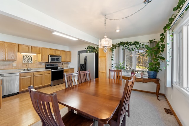 dining room featuring light hardwood / wood-style floors, an inviting chandelier, and sink