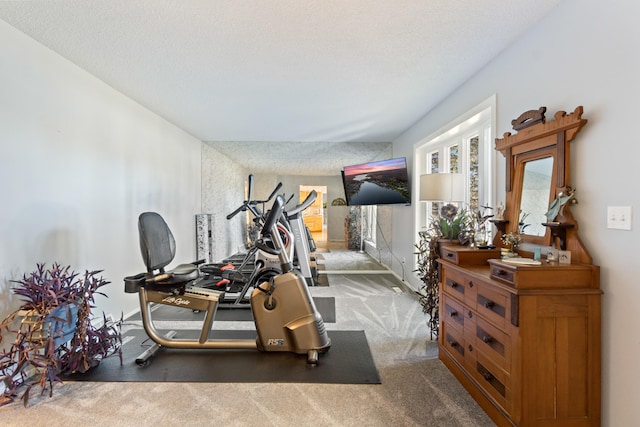 exercise room with dark carpet and a textured ceiling