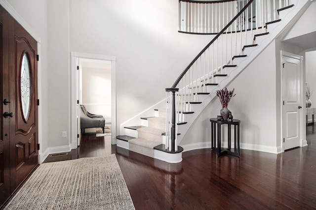 foyer featuring a high ceiling and dark hardwood / wood-style flooring