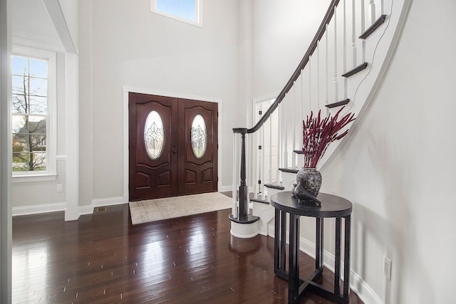 entryway with dark hardwood / wood-style floors and a high ceiling