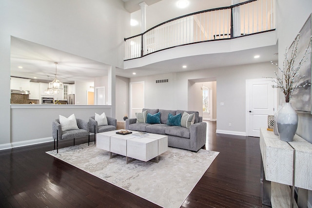 living room with dark hardwood / wood-style flooring and a towering ceiling