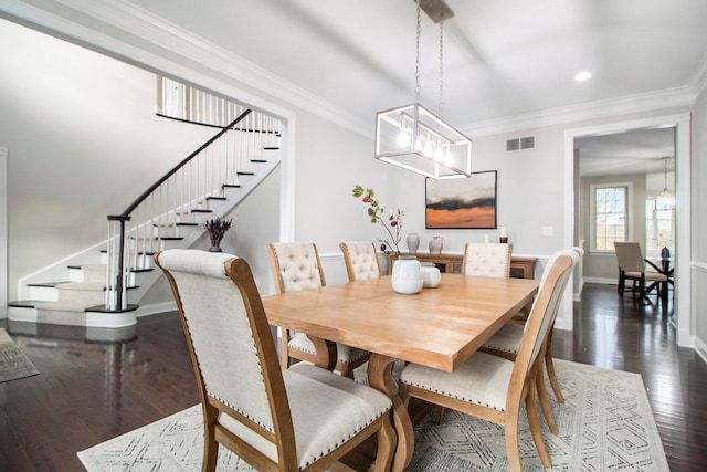 dining room with a notable chandelier, crown molding, and dark wood-type flooring