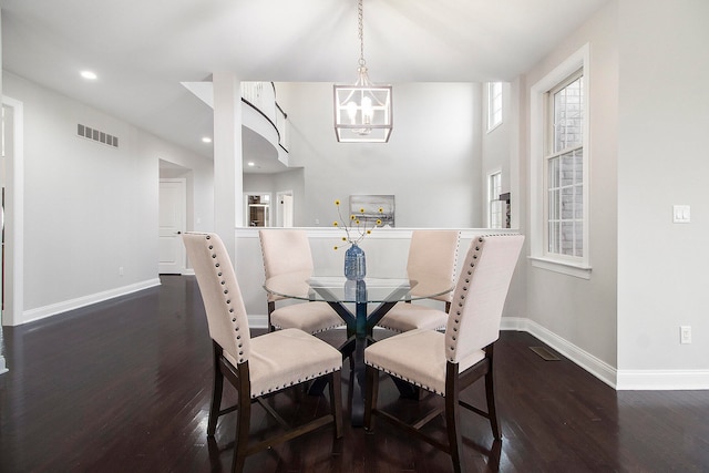 dining area featuring dark hardwood / wood-style floors and an inviting chandelier