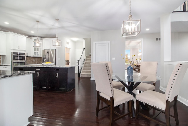 dining area with a notable chandelier and dark hardwood / wood-style floors