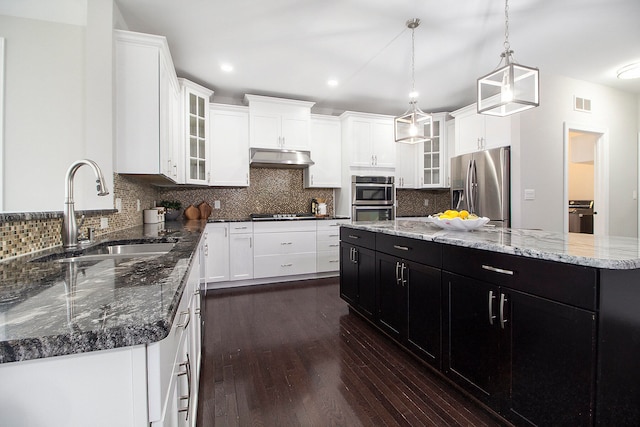 kitchen featuring a center island, sink, hanging light fixtures, stainless steel appliances, and dark hardwood / wood-style flooring