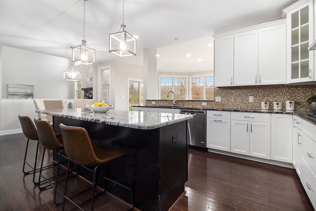 kitchen with pendant lighting, white cabinetry, dark wood-type flooring, and stainless steel dishwasher