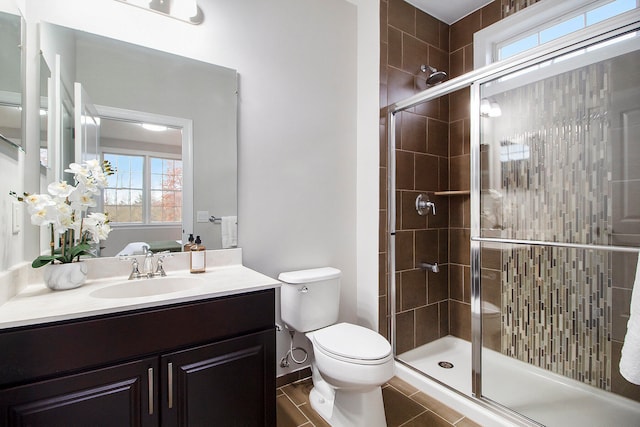 bathroom featuring vanity, toilet, and a shower with door