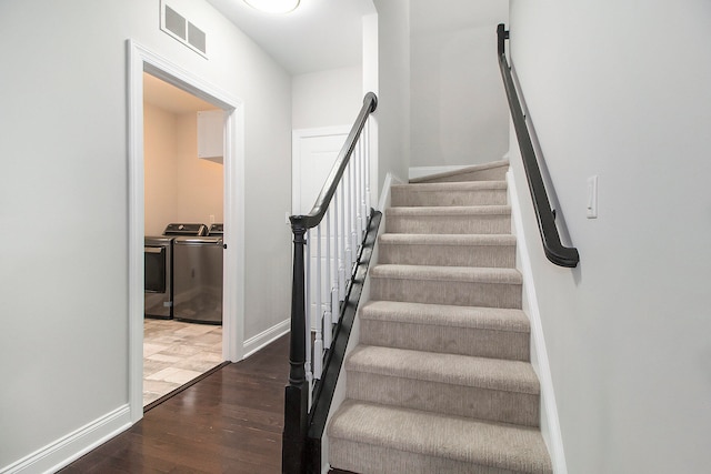 stairs with separate washer and dryer and wood-type flooring