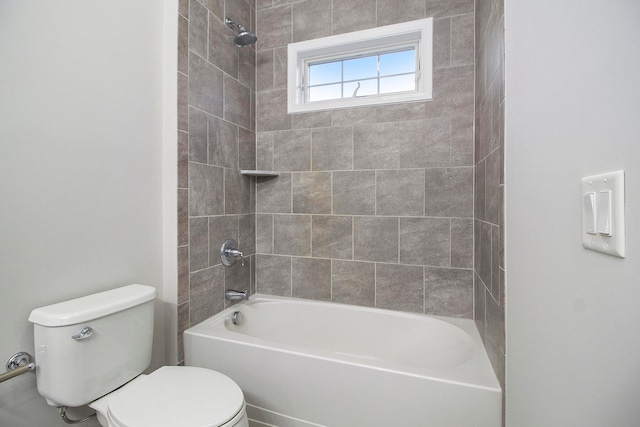 bathroom with tiled shower / bath combo and toilet