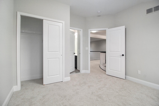 unfurnished bedroom with light carpet and a closet