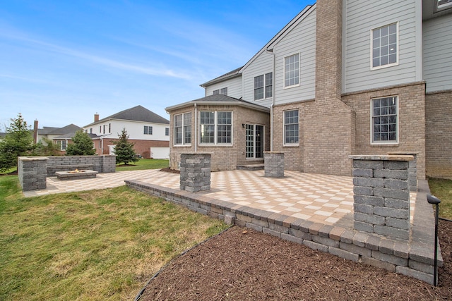 back of property with a yard and a patio