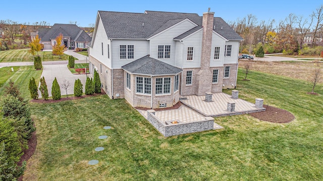 back of house featuring a lawn and a patio